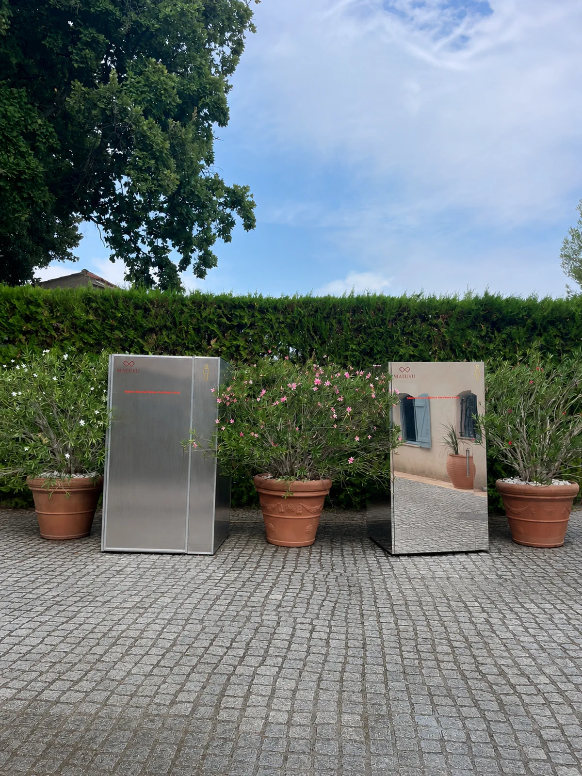 Toilettes événementielles MATUVU miroir et aluminium dans un jardin