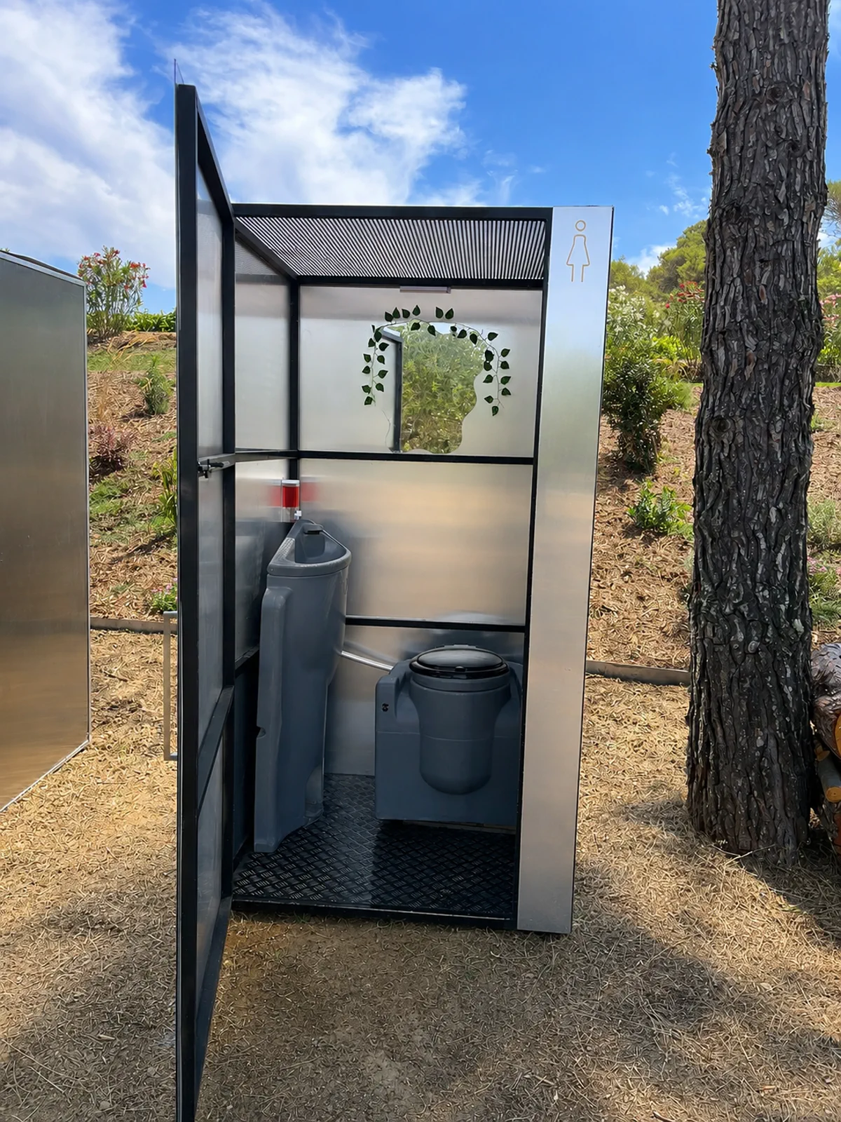 Intérieur d’une toilette MATUVU avec lave-mains intégré et miroir